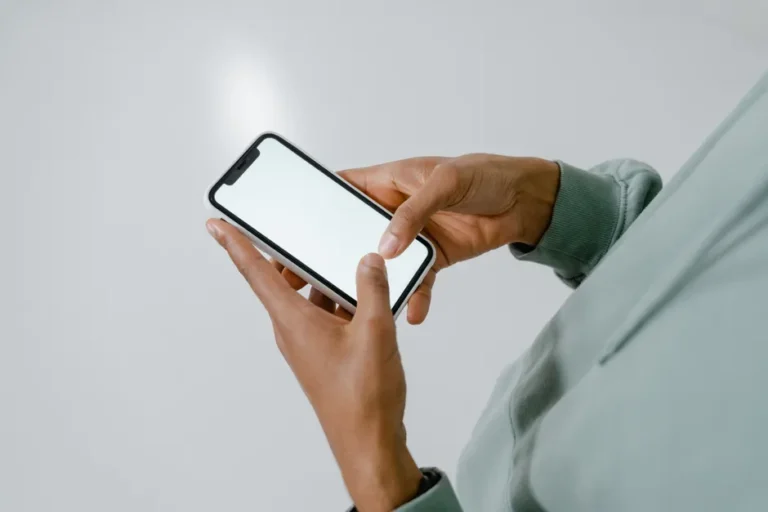 Apple News perd temporairement CNN le 24 novembre 2025 Person in hoodie interacting with a modern smartphone screen.