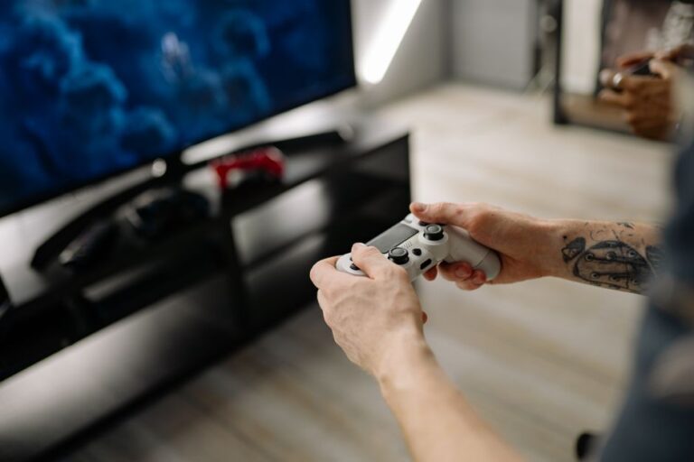 Epic Games Launcher devient natif sur Apple Silicon, cinq ans après Person playing video games using a game controller indoors on a modern TV setup.