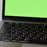 Russian keyboard MacBook Pro with a green screen. Modern electronic device.