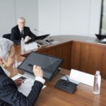 Tim Cook : Apple étudie trois successeurs pour 2026, le flambeau attend Senior executives discussing strategies in a modern boardroom setting.