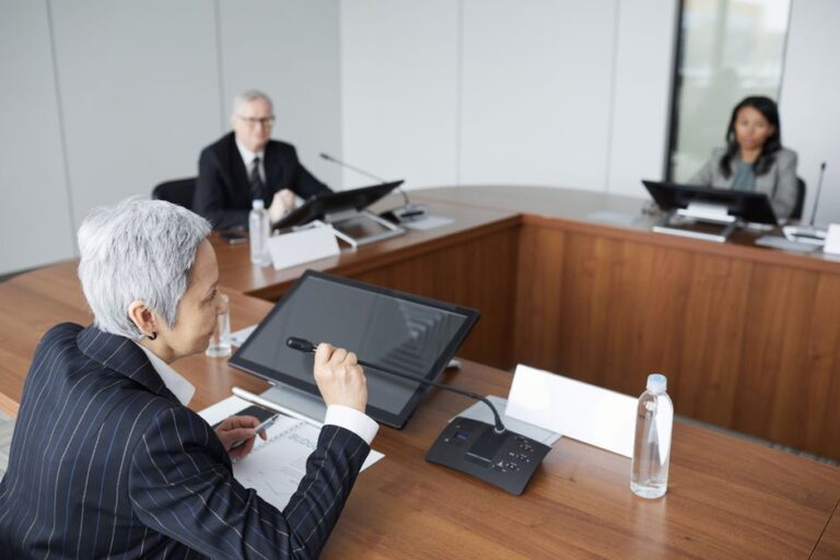 Tim Cook : Apple étudie trois successeurs pour 2026, le flambeau attend Senior executives discussing strategies in a modern boardroom setting.