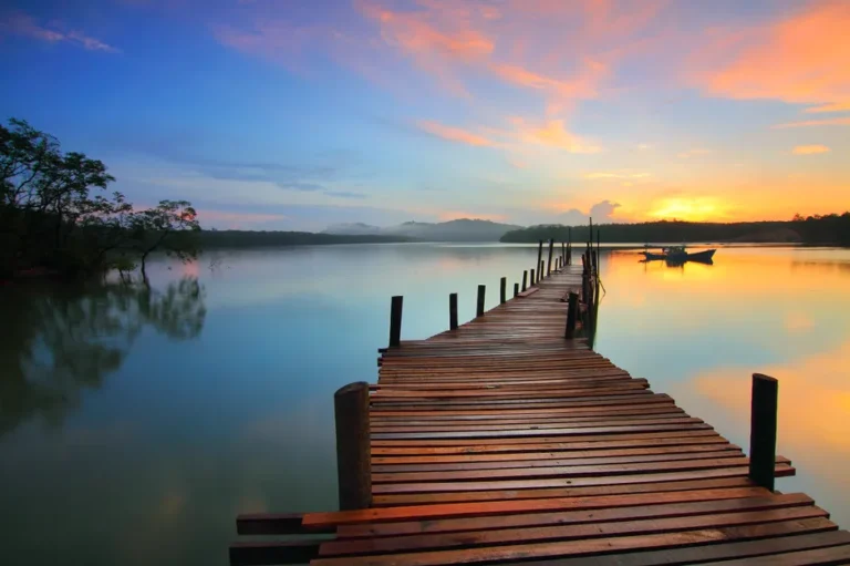 Docks Thunderbolt 5 Kensington : 140 W, deux écrans 6K, mais pas pour tous les Mac Serene sunset view over a tranquil lake with a wooden dock stretching into the distance.