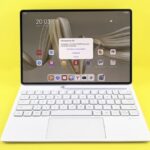 Sleek tablet with keyboard displaying a screen update prompt on a vibrant yellow background.