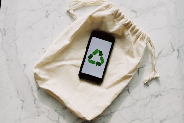 Smartphone displaying recycling icon on a drawstring pouch. Eco-conscious and sustainable theme.
