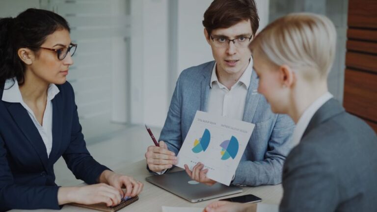 Apple réorganise sa force commerciale le 24 novembre 2025 : des dizaines de postes touchés Team of professionals discussing sales strategies with charts in a modern office.