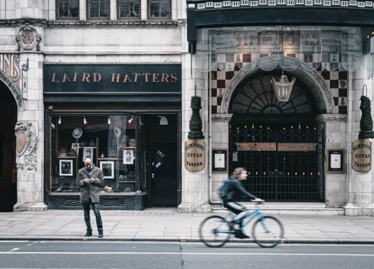 Londres 2025 : Samsung rendus, iPhone davantage ciblés Urban street photo in London showing classic storefronts and a cyclist in motion.