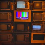 YouTube TV 2026 : Sports à 44,99 $, le prix après promo A collection of vintage televisions featuring static and color test patterns on the screens.