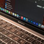 MacBook Air M4 à 1 099 dollars : 24 Go, le M5 en embuscade A detailed view of a MacBook Air with a focus on the keyboard and screen displaying app icons.