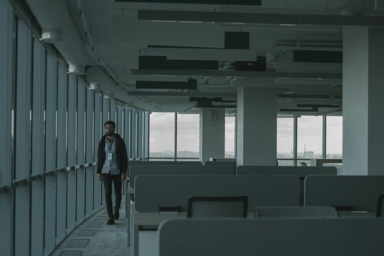 Campus Apple en Caroline du Nord : 2027, le reboot d’un projet annoncé à 1 milliard A dimly lit empty office space with one person walking, providing an atmosphere of isolation.