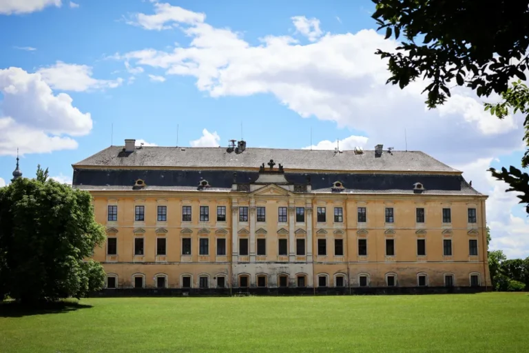A large historic manor in Europe on a sunny day with blue sky.