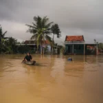 Apple promet un don en Asie le 2 décembre 2025, mais le montant reste inconnu A man paddles a boat through a flooded village in Phú Yên, Vietnam, under cloudy skies.