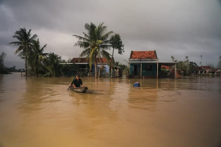 Apple promet un don en Asie le 2 décembre 2025, mais le montant reste inconnu A man paddles a boat through a flooded village in Phú Yên, Vietnam, under cloudy skies.