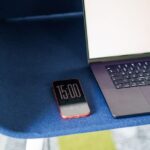 MacBook Air M4 15 pouces : 949 dollars le 19 décembre, puis 999 le 31 A minimalist workspace featuring a laptop and smartphone on a stylish blue chair.