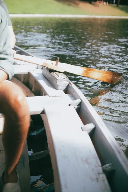 A person enjoying a peaceful rowing trip on a tranquil lake, surrounded by nature.