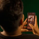 Black Friday 2025 : Apple TV+ à 5,99 dollars et Max à 2,99 dollars A person using a smartphone to stream music from a streaming service app indoors.