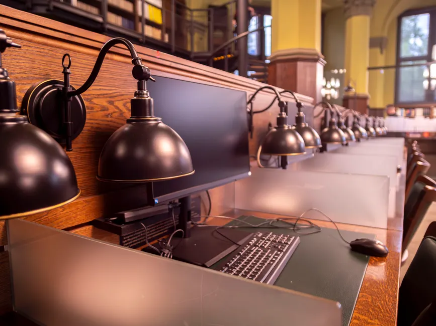 A row of computer workstations in a modern library in Wrocław, Poland, emphasizing technology and learning.