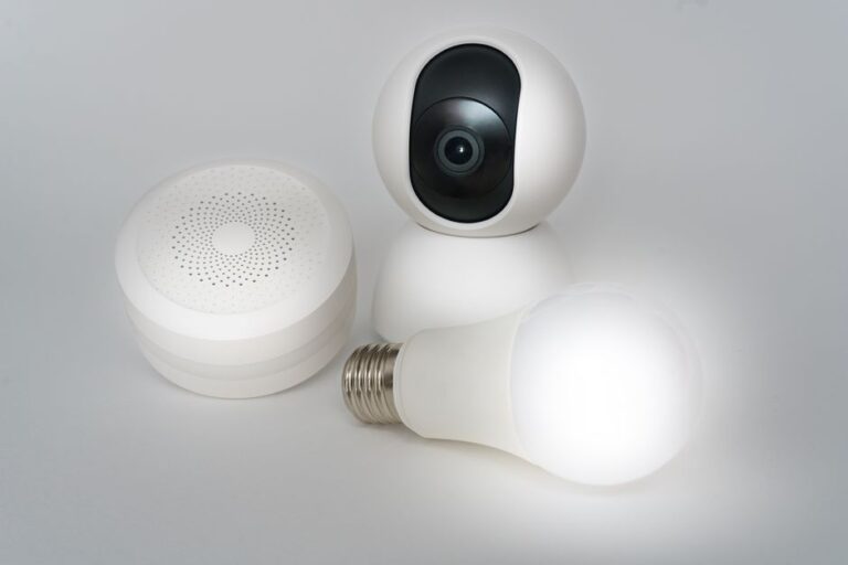 Aqara baisse ses verrous et caméras jusqu’à 37 % pour Black Friday 2025, mais Apple garde la clé A set of smart home devices including a camera, speaker, and lightbulb on a white background.