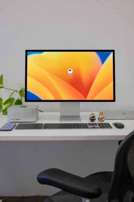 A sleek office setup featuring a desktop computer, keyboard, and accessories on a clean white desk.