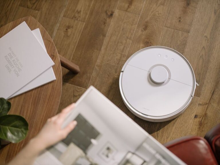 Roborock au Black Friday 2025 : jusqu’à 650 dollars, mais le dock tranche A sleek robot vacuum cleaner operating on a wooden floor, symbolizing modern home technology.