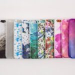 Coques bandoulière iPhone 17: 39,99 ou 47,99 dollars, Apple garde la laisse A vibrant collection of variously patterned iPhone cases arranged on a white surface.