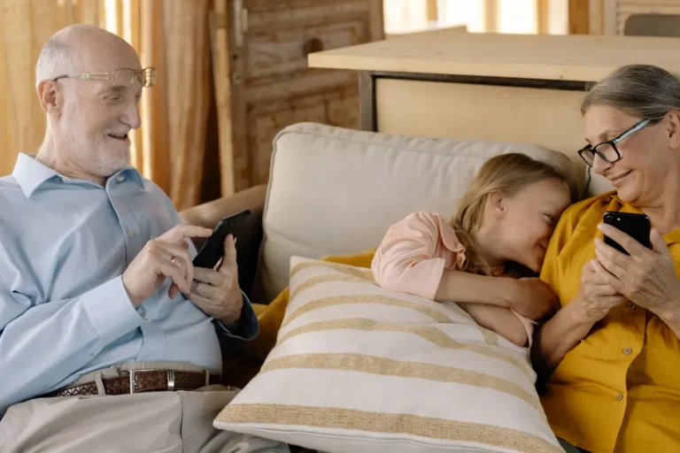 Black Friday 2025: quatre iPhone 17 à 0 dollar chez T-Mobile, avec 24 mois de crédits A warm family moment with grandparents and granddaughter using smartphones on a cozy sofa.