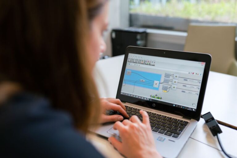 Apple change de pilotes : Alan Dye chez Meta, Giannandrea prend sa retraite A woman engineer focuses on software analysis using a laptop indoors.