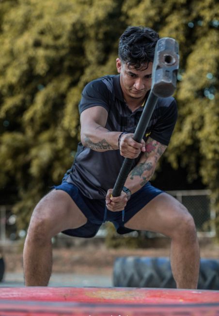 A young male athlete swings a sledgehammer during an outdoor workout in Managua, Nicaragua.