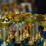 Array of golden trophies on a table, reflecting victory and achievement.