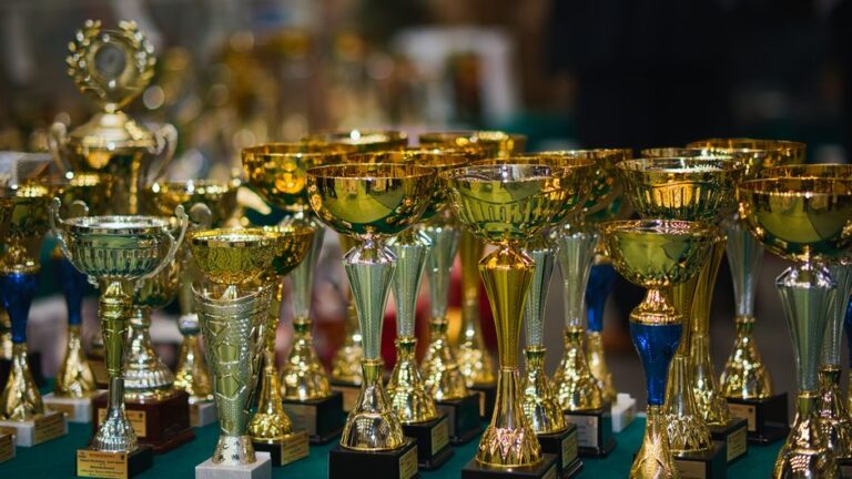 Golden Globes 2026 : Apple TV aligne 14 nominations, le jardin clos s’expose Array of golden trophies on a table, reflecting victory and achievement.