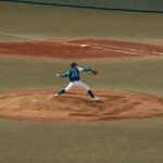 Baseball player mid-throw during a game at a Tokyo baseball field. Capturing the intensity and focus of sports.