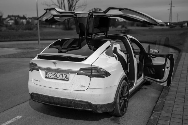 Apple Car Key dans les Tesla : le code de décembre 2025 entrouvre la porte Black and white photo of Tesla Model X with open falcon wing doors in Garešnica, Croatia.