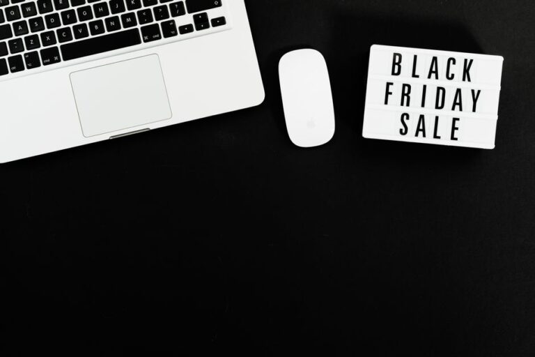 Black Friday sale sign with a laptop and mouse on a black background. Perfect for online shopping promotions.