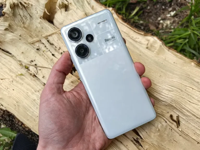 iPhone Air 2 en 2026? Le calendrier fait du yo-yo Close-up of a hand holding a modern white smartphone with dual lenses outdoors.