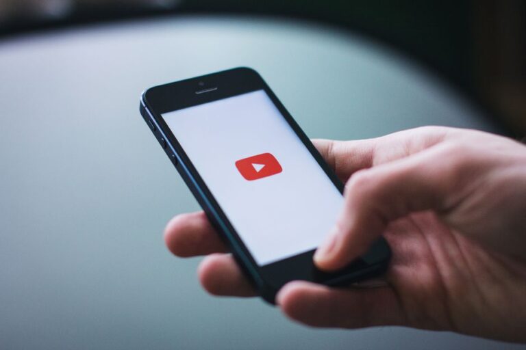 iPhone 17 : Apple pourrait rester numéro un des ventes jusqu’en 2029, Android garde le royaume Close-up of a hand holding a smartphone displaying the YouTube app on the screen.
