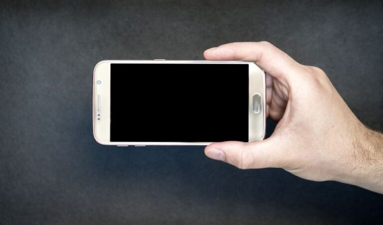 Tim Cook, AirDrop sur Pixel et grip Hikawa : Apple desserre l’étau le 28 novembre 2025 Close-up of a hand holding a smartphone with a blank screen, ready for design mockup.