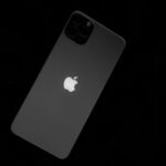 iPhone 17e en 2026 : les bordures s'affinent, pas le 60 Hz Close-up of a sleek smartphone featuring the iconic Apple logo against a black background.