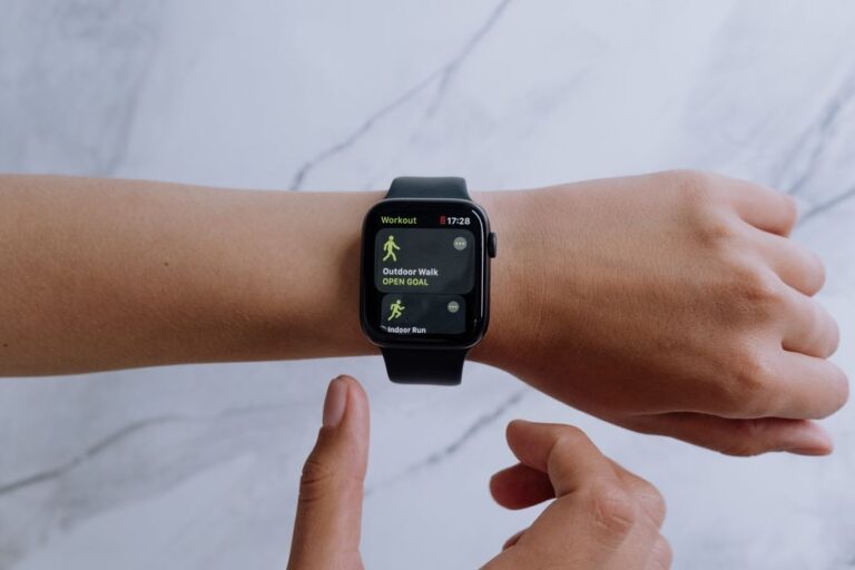 Apple Watch et résolutions 2026 : 60 % progressent, mais la montre ne fait pas tout Close-up of a smartwatch on a wrist displaying health and fitness apps with a marble background.