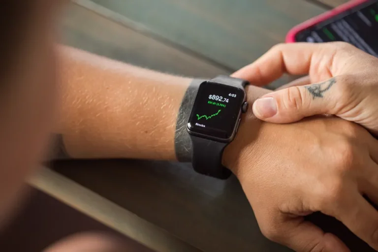 Apple Watch Series 11 à 299 dollars pour le Nouvel An 2026 : le rabais reste américain Close-up of a smartwatch showing stock market data, with hands wearing it.