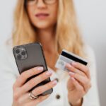 iPhone 16 et 5 000 dollars : la sécurité Apple face au vol en 2025 Close-up of a woman using a smartphone and credit card for online shopping.