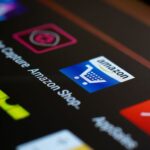 App Store au Brésil : Apple devra ouvrir l'iPhone en 2026, mais garde la caisse Close-up of the Amazon shopping app icon on a smartphone screen. Ideal for online shopping and technology themes.