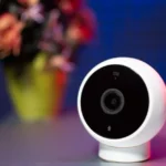 Apple Home en 2025 : 4 appareils tiers, du verrou au robot Close-up shot of a modern circular security camera with blurred background.
