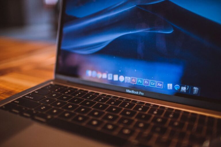 Black Friday 2025 : 5 docks Thunderbolt 4 et 5 jusqu’à 35 % moins chers Close-up view of an open MacBook Pro with a dim blue screen in a cozy indoor setting.