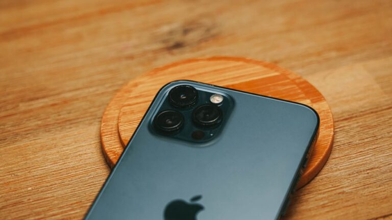 iPhone Air, Powerbeats Pro 2 et Vision Pro M5 : les choix tech 2025 qui dépassent la fiche technique Detailed close-up of a modern smartphone camera on a textured wooden surface.