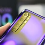Detailed view of a smartphone with AI quad camera and reflective surface, highlighting its design.