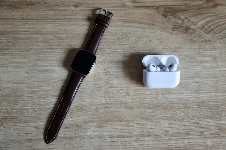 AirPods Pro 3 à 199 $ le 3 septembre 2026 : la promo qui pique Flat lay of a smartwatch and wireless earbuds on a wooden surface, emphasizing modern EDC essentials.