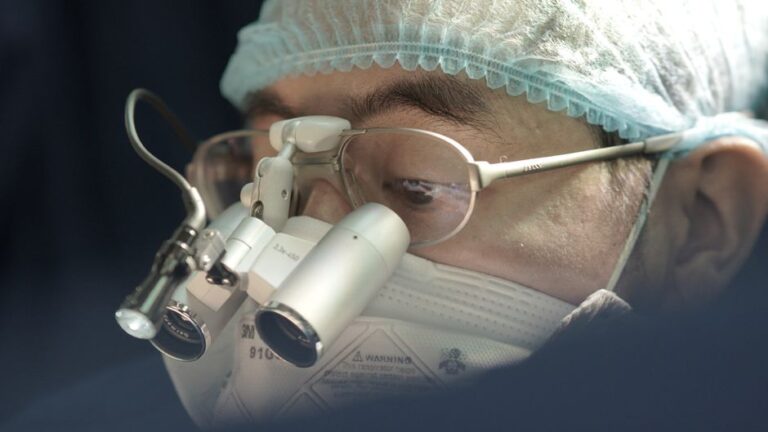 Apple Vision Pro au bloc : 90 % sur une tâche, pas partout Focused surgeon wearing a surgical mask and loupes during an operation.