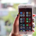 Sanchar Saathi sur l'iPhone : Apple face à l'ordre indien des 90 jours Hand with colorful nails holding a smartphone showing app icons, captured outdoors in Patna, India.