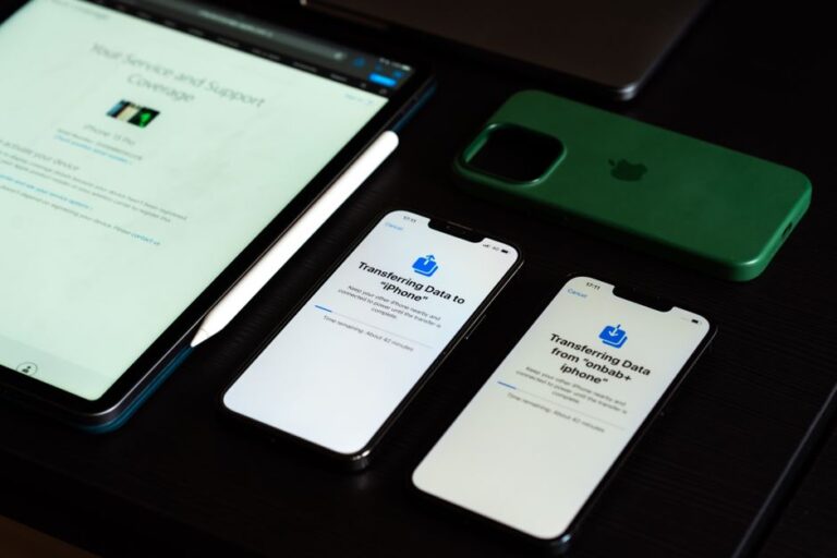iOS 26.3 prépare le transfert vers Android, mais garde ses cadenas High-angle view of digital devices including iPhones and an iPad on a desk, showcasing data transfer.