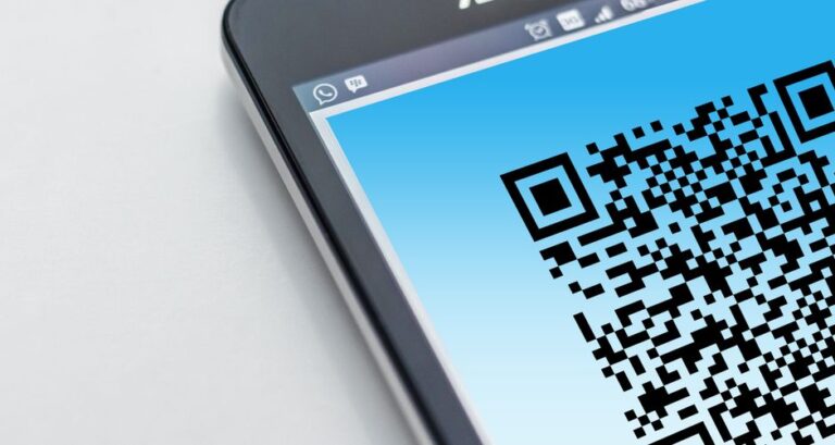 iPhone vers Android: le transfert sans fil arrive en 2026, avec quelques cadenas High-resolution close-up of a smartphone displaying a QR code on its screen.