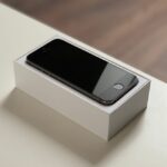 iPhone 17 : Apple vise 247,4 millions d’iPhone en 2025, mémoire sous tension Minimalistic image of a smartphone on its packaging, ideal for tech and gadget themes.